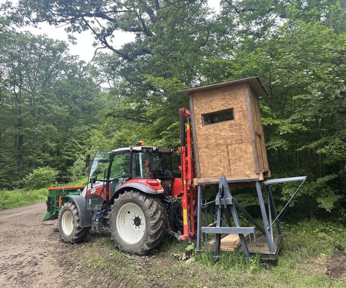 Neue Steyr Traktor in rot & weiß gebt einen Jägersitz im Wald an